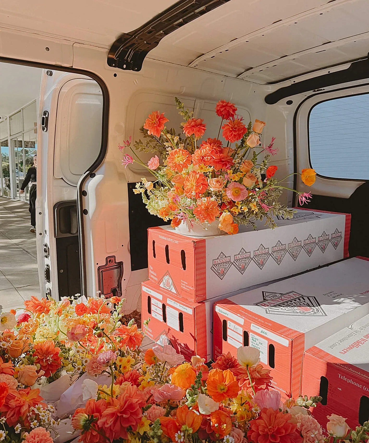 Bright florals stacked on boxes ready for delivery by Poppy Rose Brisbane