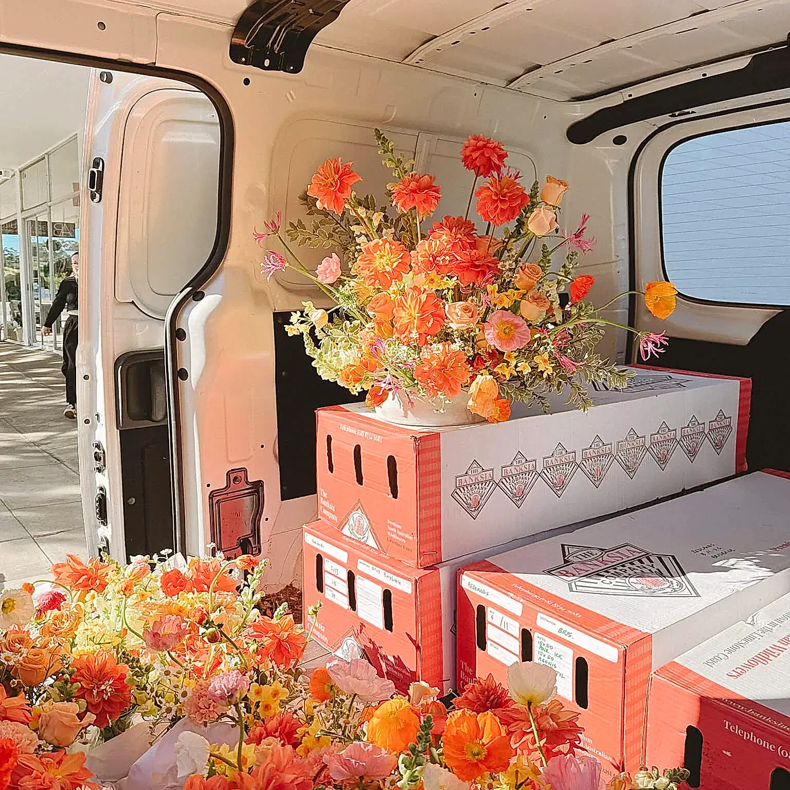 Bright florals stacked on boxes ready for delivery by Poppy Rose Brisbane