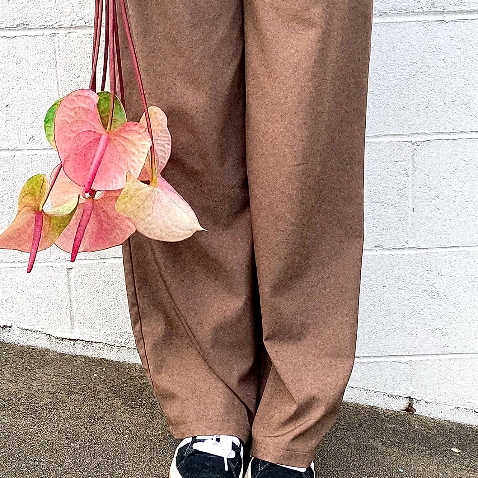 A lady in brown pants holding Anthuriums - Poppy Rose Flower Delivery in Brisbane