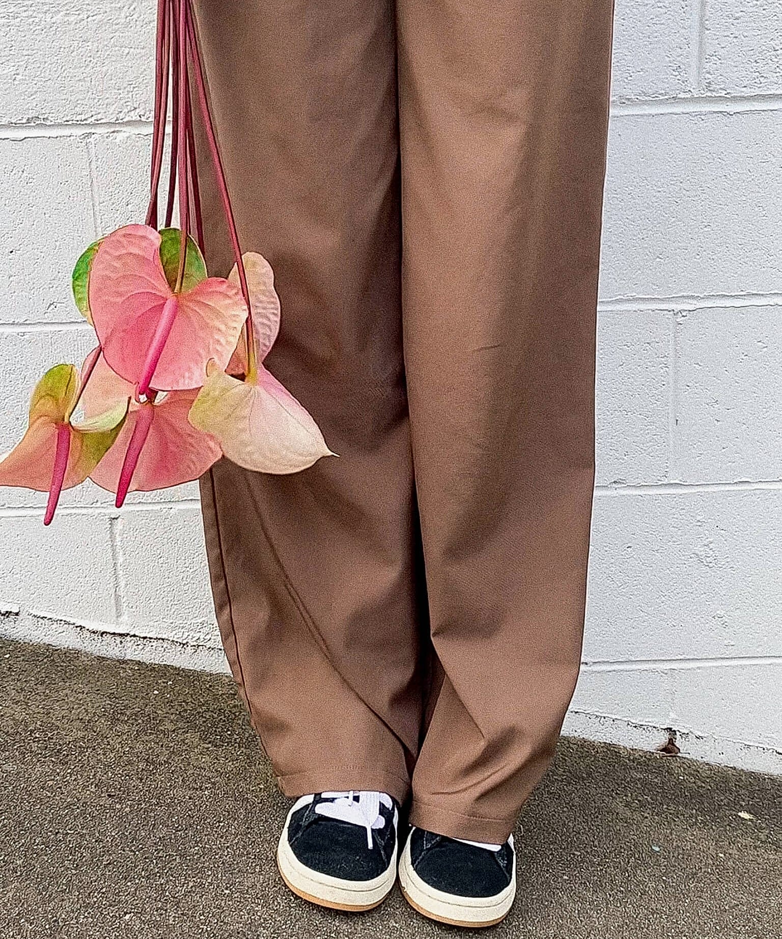 A lady in brown pants holding Anthuriums - Poppy Rose Flower Delivery in Brisbane